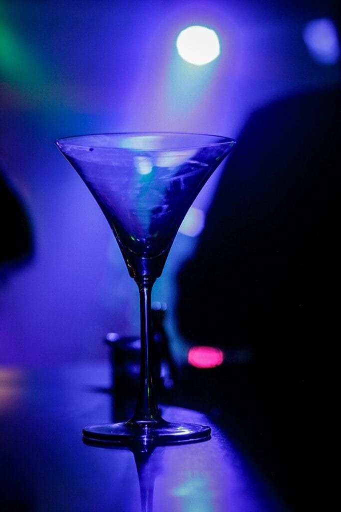 pexels-photo-724259-724259 A crystal martini glass glows under vibrant nightclub lighting.